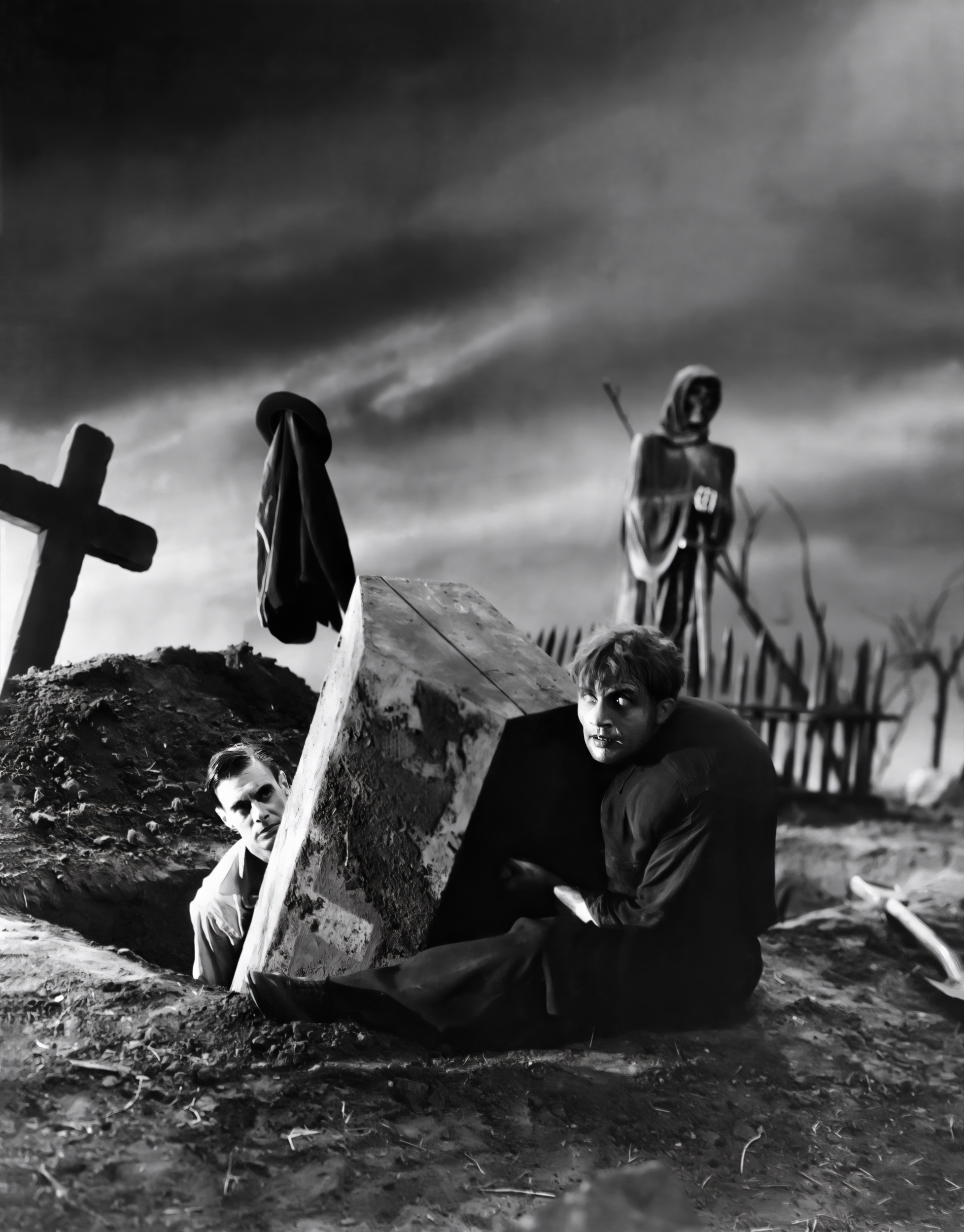 Two figures beside an open grave under a dark sky, referencing the Frankenstein "assembling the body" scene
